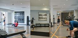 Resident's Facilities - gym with many pieces of equipment and a centred mirror