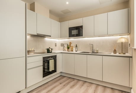 Kitchen with white panels, light grey countertops, modern comfort appliances.