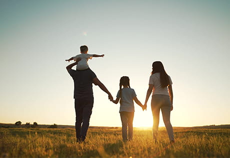 An image of a family walking at sunset together