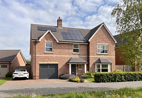 CGI of a new build home with solar panels on roof, private off street parking.