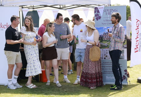 Closeup of people in summer attire enjoying the outdoors under a shaded tent