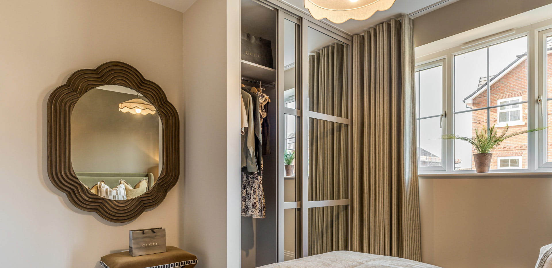 Closeup of bedroom wall hanging mirror, wardrobe and window