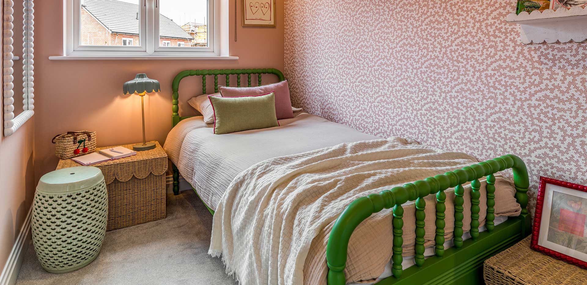 An interior Bedroom with a green bed and pink patterned walls at Winterbrook Meadows
