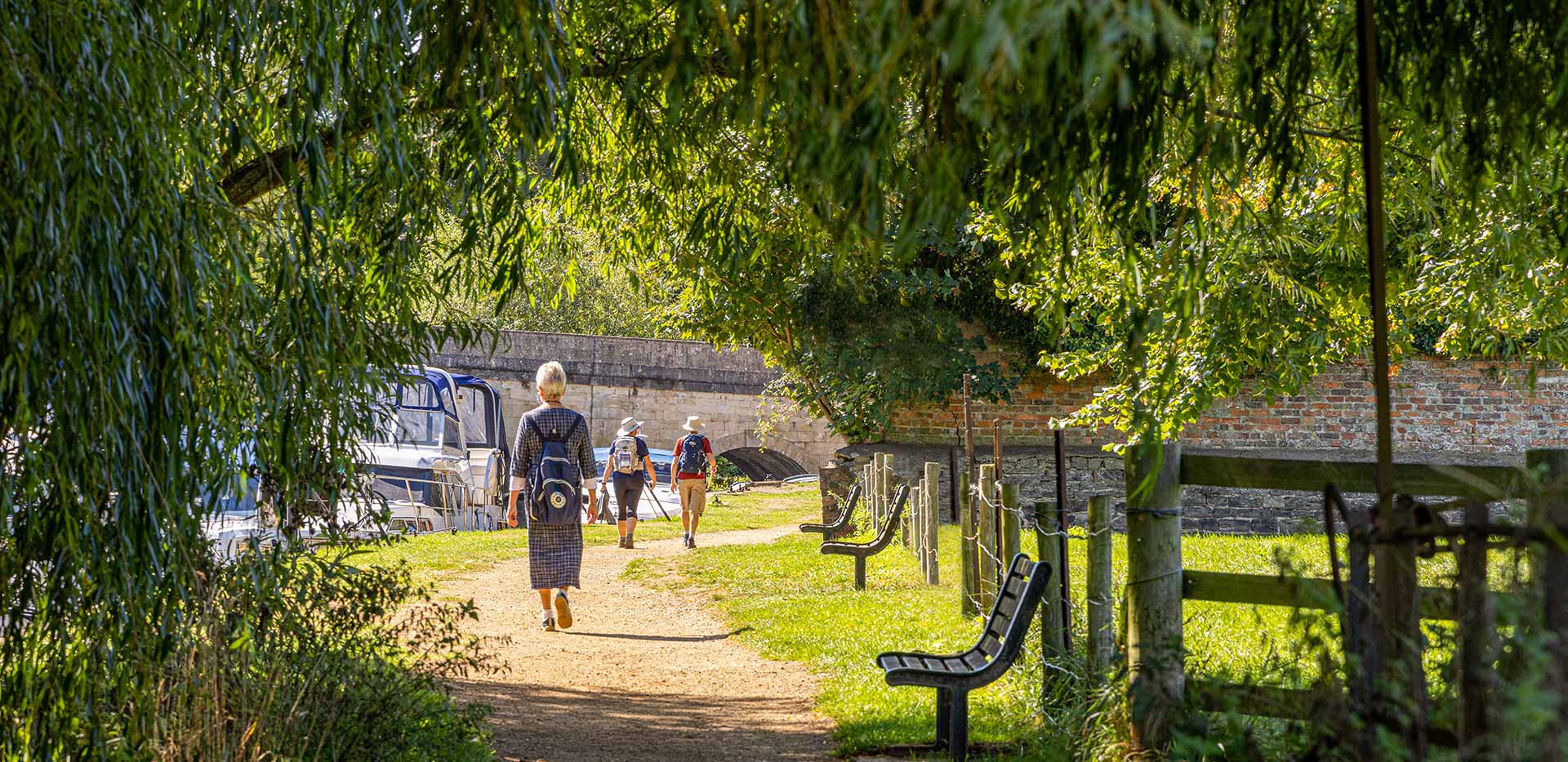 Members of the public walking along the rivers edge 