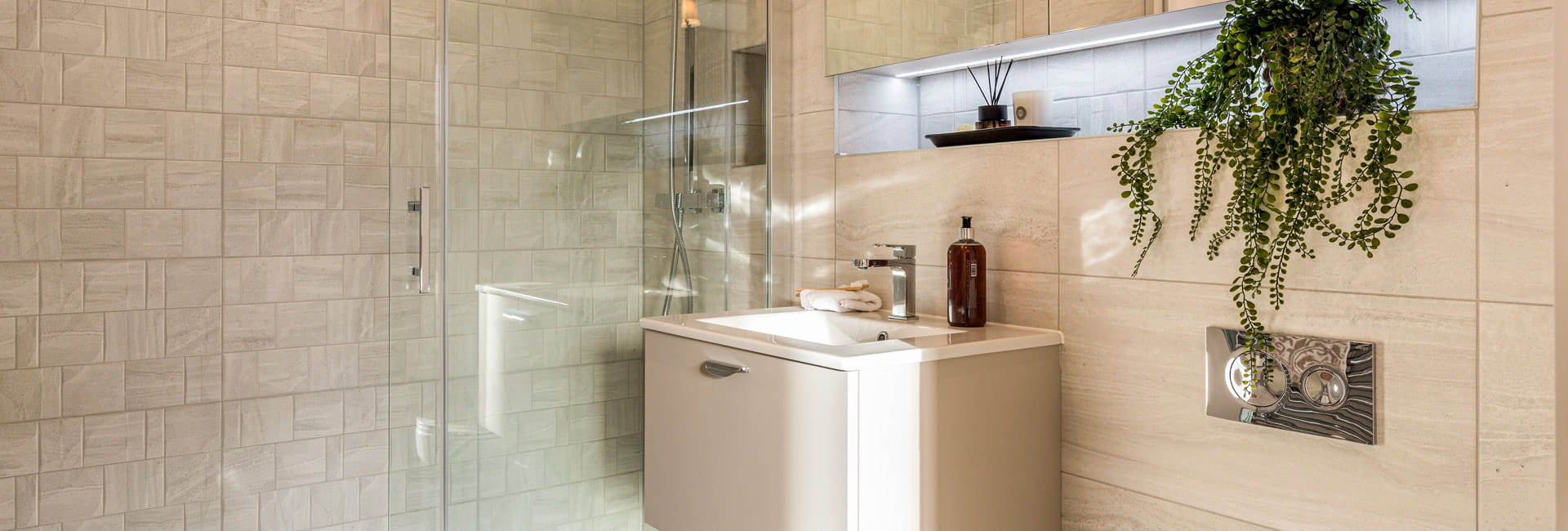 Modern designed bathroom with shower unit, wash basin, strip lighting, shelf and cabinet space