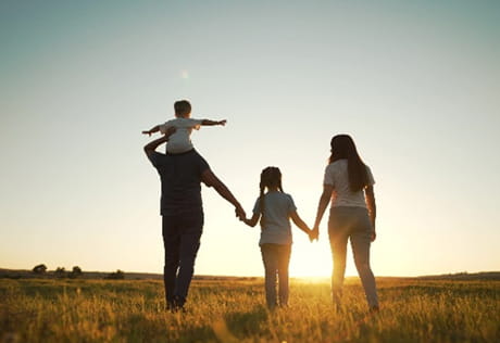 Image of family watching sunset in open field
