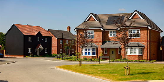 CGI of new build homes with newly constructed drive, grassed areas.
