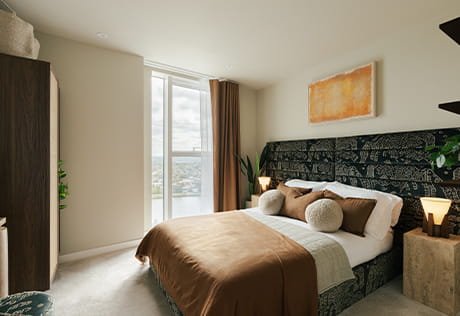 An interior image of a Bedroom with a dark coloured headboard from the Woodberry Down Showhome