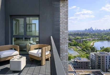 CGI of a balcony view with grey exteriors and outdoor furniture overlooking a suburban landscape.