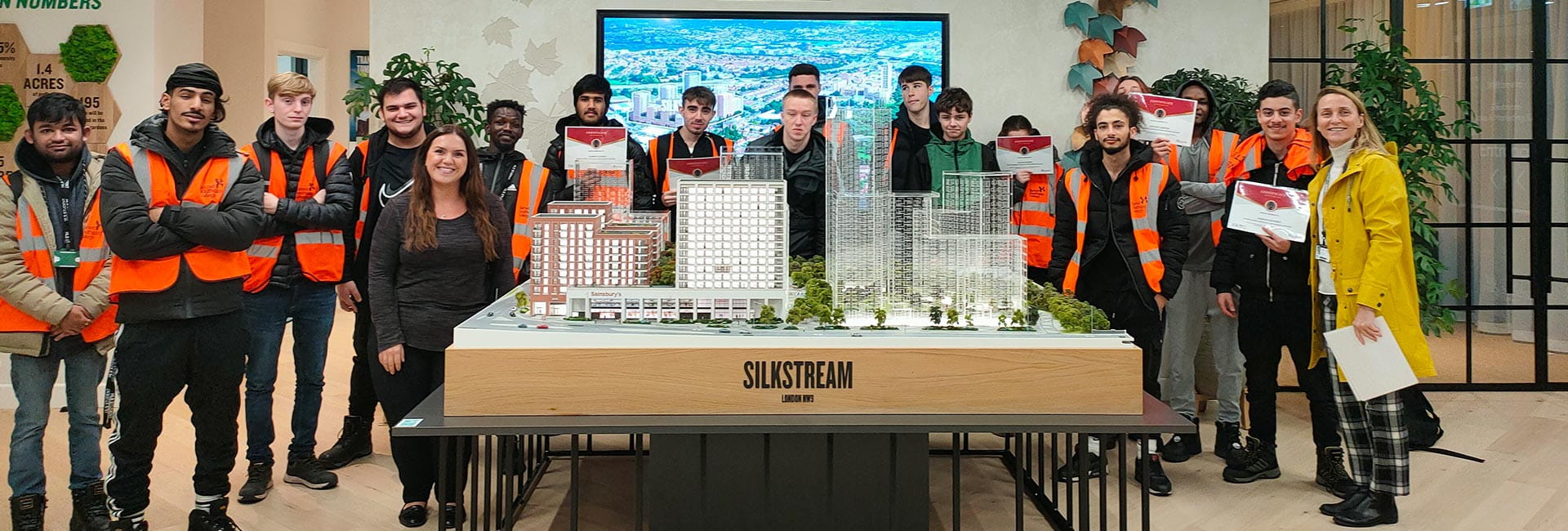 People Standing Around a Miniature Model of Silkstream