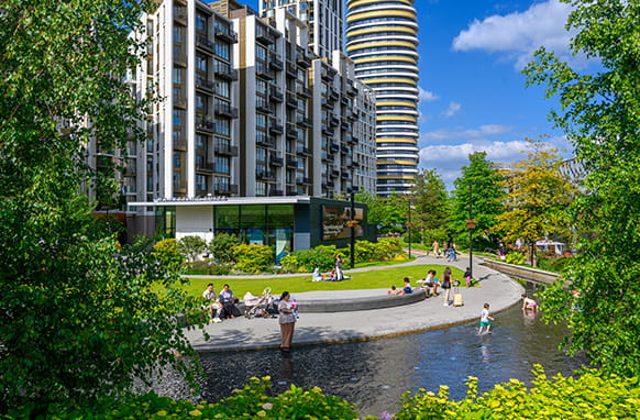 A vibrant exterior image of White City Living on a warm sunny day with residents enjoying the facilities