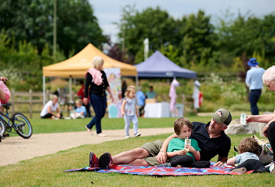 A image of a young family relaxing in the sun at the Picnic in the Park event