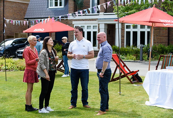 An image of people standing and chatting enjoying Oakhill's Summer Home and Lifestyle Showcase