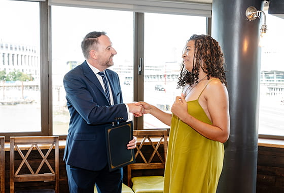 An image of an apprentice collecting a completion award for their work