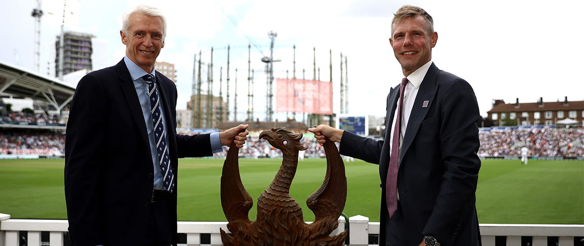 Image of Surrey County Cricket Club posing with a statue of the Phoenix