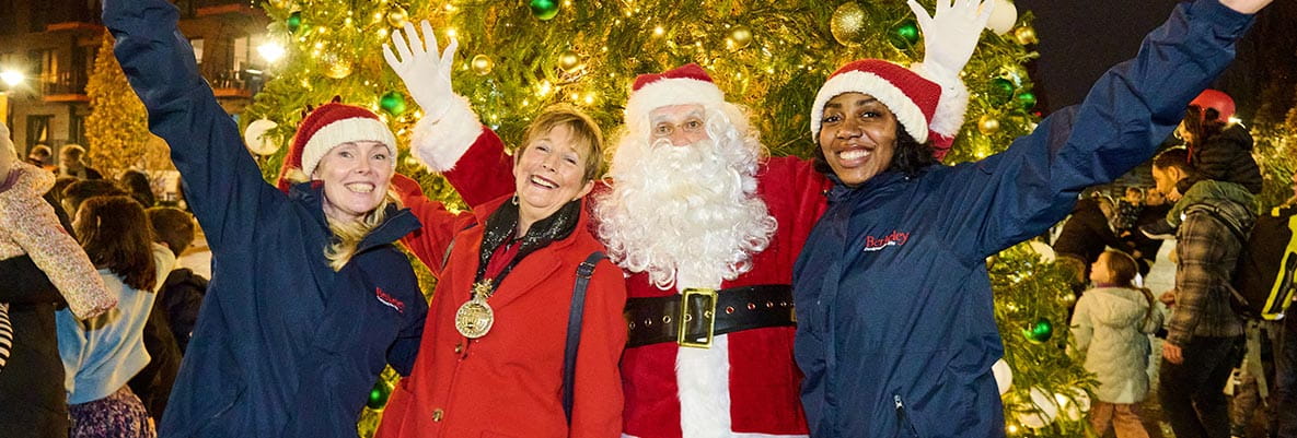 An image of the Royal Arsenal Riverside Staff with Santa in front of a giant Christmas Tree