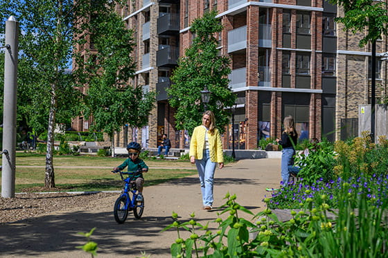 An image of a child riding a bike near a Berkeley development