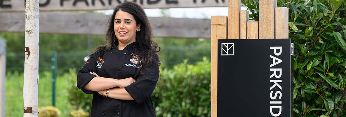 An image of Dipna Anand outside next to the Parkside Yards Entrance