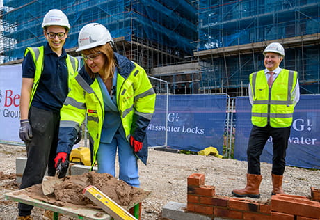 An image of the Chancellor trying out some brick laying at Glasswater Locks