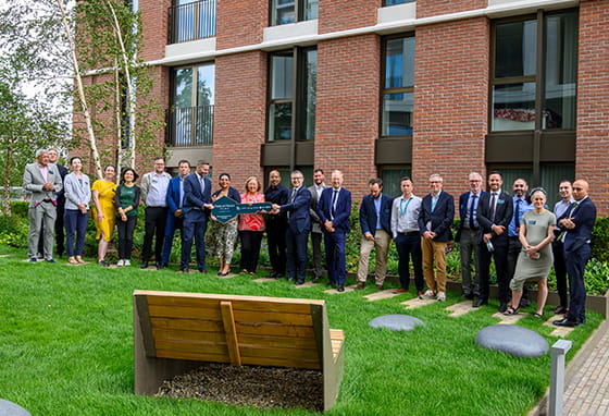 An image of all partners of TwelveTrees Park holding a sign in the shape of a key