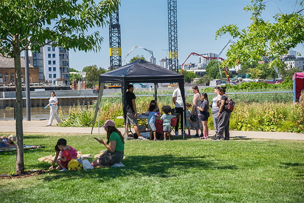An image of local residents sitting under a gazebo at the park