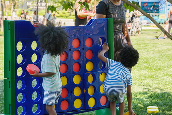 An image of young children playing a giant connect four game