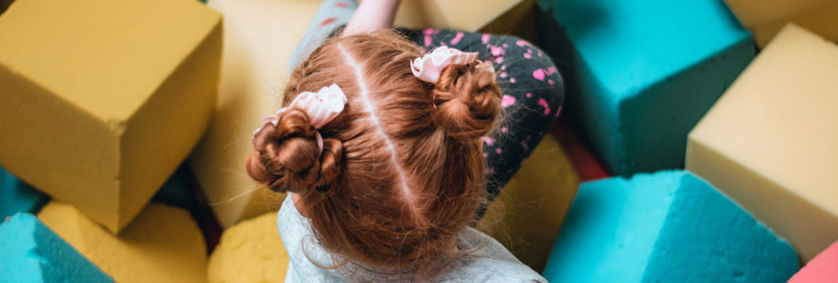 An image of a young girl playing in a soft play area