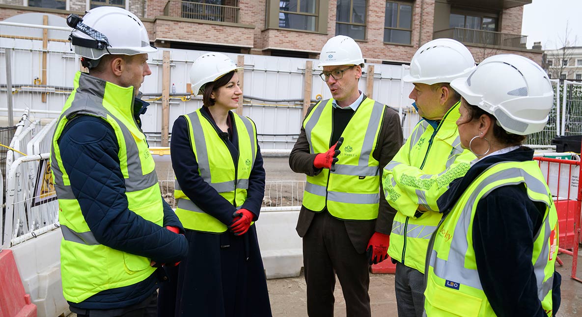 An image of Berkeley staff with the Secretary of State for Education talking at Oval Village 