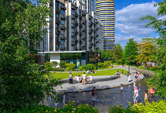 An exterior of White City Living water feature with children playing