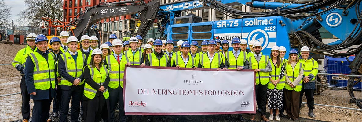 An image of people in construction workers in front of construction equipment