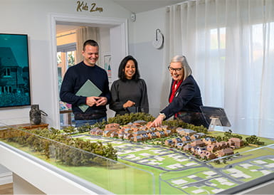 Property sales person showing prospective buyers model version of a development