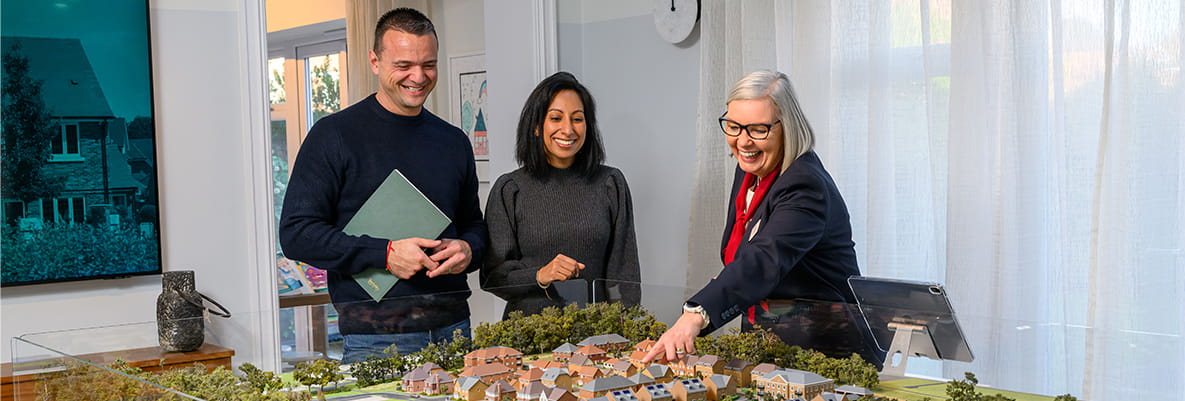 Property sales person showing prospective buyers model version of a development