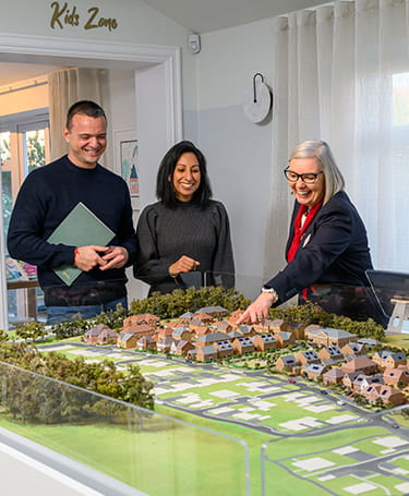 Property sales person showing prospective buyers model version of a development