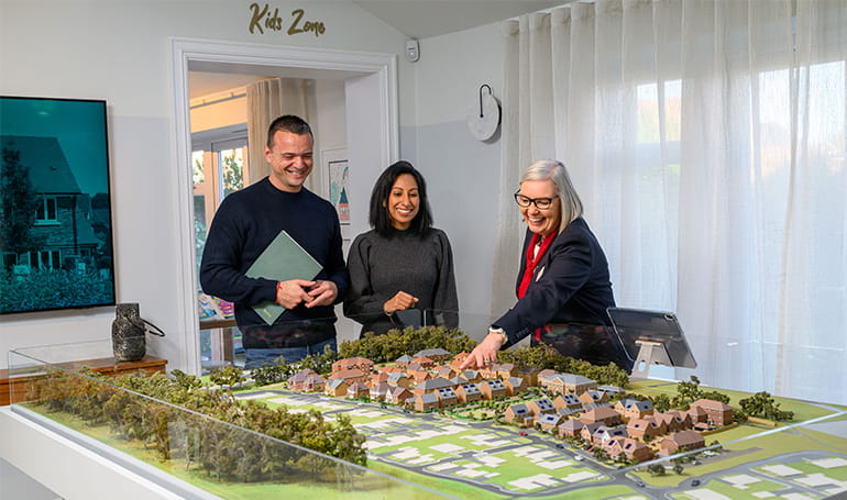 Property sales person showing prospective buyers model version of a development