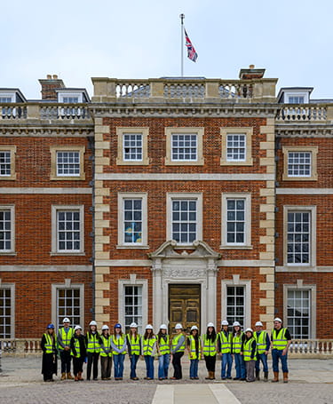 An image of people outside a Berkeley development in PPE who are visiting