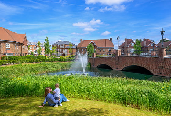 An exterior photograph of the green space by the bridge entrance to Hartland Village